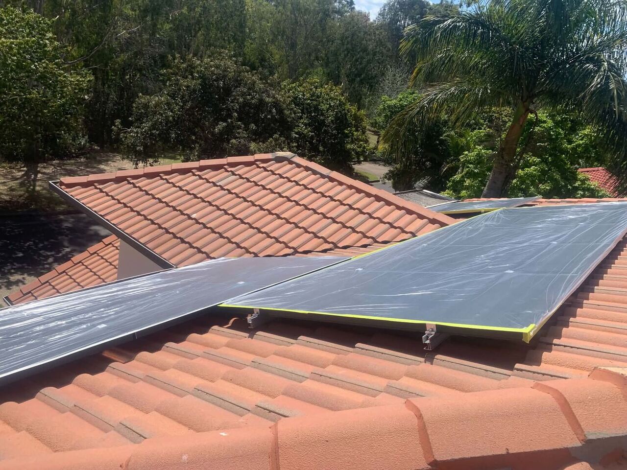 Restored terracotta roof worked around solar panels in Brisbane